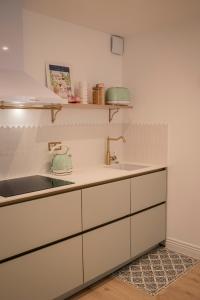 a kitchen with white cabinets and a sink at Mon cocon au cœur du village et des plages in Bandol +37 photos