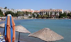 達特恰的住宿－弗拉公寓酒店，两把遮阳伞坐在海边