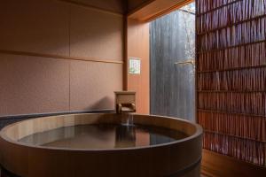 una grande vasca da bagno in una stanza con libri di 越中井波町屋旅館古香里庵 a Nanto