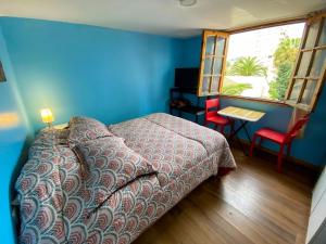 a bedroom with a bed and a table and a window at Hostal EntreOrientes in Viña del Mar