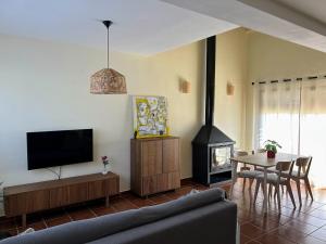 ein Wohnzimmer mit einem TV und einem Kamin in der Unterkunft Casa Rural Sierra Norte 68 in El Ronquillo