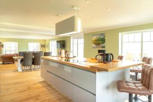 a kitchen with a counter and chairs in a room at Gutshof-Penthouse-Wohnung- Seeblick in Klein Upahl