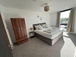 a bedroom with a bed and a wooden cabinet at Luxury central York Apartment in York