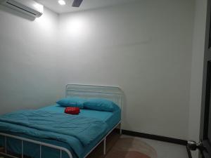 a bed with blue pillows in a white room at Umieta Homestay in Johor Bahru