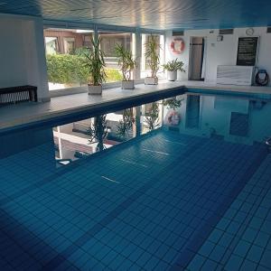 a swimming pool with potted plants on the side at Ferienwohnung Oshowski in Berchtesgaden