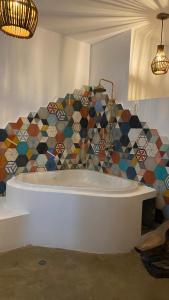 bañera en una habitación con una pared de mosaico en Dada, en Brisas de Zicatela 34 fotos más