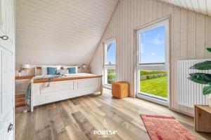 a bedroom with a bed and two windows at Ferienhaus Lachmöwe Olpenitz in Olpenitz