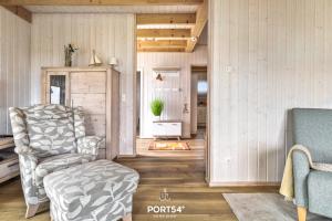 a living room with a chair and a couch at Ferienhaus Lachmöwe Olpenitz in Olpenitz