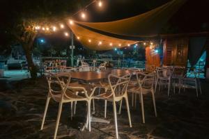 un grupo de mesas y sillas bajo una tienda por la noche en Soficu Hotel on the beach bayahibe, en Bayahibe