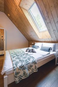 a bedroom with a large bed with a window at Mazury Twin House in Wynki +44 photos