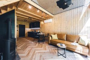 a living room with a couch and a stove at Mazury Twin House in Wynki