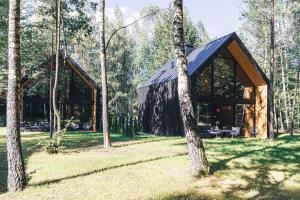a wooden cabin in the middle of a forest at Mazury Twin House in Wynki