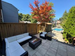 a patio with a white couch and a tree at Leaside Rental with Great Backyard & Pool in Toronto