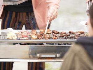 a person is cooking food on a grill at 月兎園 in Yoshioka