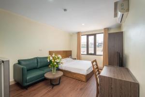 a bedroom with a bed and a couch and a table at Granda Hanoi Hotel & Apartment in Hanoi