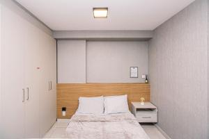 a bedroom with a large bed with a wooden headboard at Nosso Apê 915: Central | Academia | Piscina NA0714 in Juiz de Fora