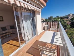 ein Balkon eines Hauses mit einem Tisch und Stühlen in der Unterkunft Appartement 2P climatisé avec WIFI, piscine, parking privé, proche plages et centre Sainte-Maxime - FR-1-780-1 in Sainte-Maxime