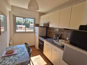 eine kleine Küche mit Tisch und Spüle in der Unterkunft Appartement 2P climatisé avec WIFI, piscine, parking privé, proche plages et centre Sainte-Maxime - FR-1-780-1 in Sainte-Maxime