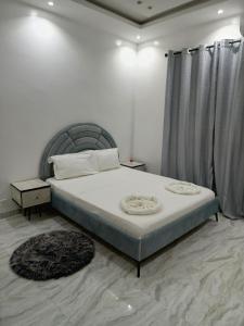 a bedroom with a large bed with a gray headboard at LOCABISS 3-Madina in Rufisque