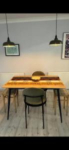 een houten tafel met een groene stoel en twee lampen bij Riverside Retreat with Balcony, Workspace & Parking in Richmond +7 foto's