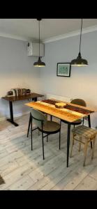 een houten tafel en stoelen in een kamer bij Riverside Retreat with Balcony, Workspace & Parking in Richmond