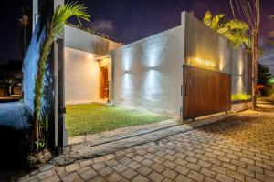 wejście do domu z drewnianymi drzwiami w obiekcie Villa Luna - Sanur, Bali 3 Bed Modern Private Villa with swimming pool w mieście Sanur