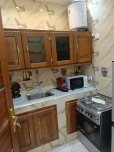 a small kitchen with a sink and a microwave at LOCABISS 3-Madina in Rufisque +9 photos