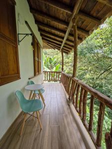 a wooden porch with a table and a chair at Caminos Alojamiento in Jardin