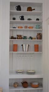 a white shelf filled with bowls and plates at Ferienwohnungen am Stadtpalais - Bernkastel in Bernkastel-Kues