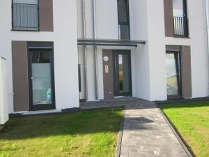 a white building with a person standing outside of it at Ferienwohnung im Kirschfeld - 5* in Kues