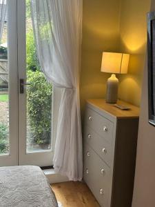 a bedroom with a window and a dresser with a lamp at My Sky - Serviced House well situated in London