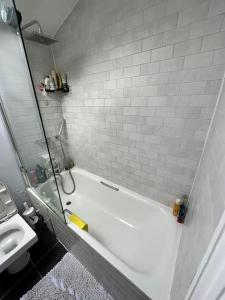 a bathroom with a white tub and a sink at My Sky - Serviced House well situated in London +33 photos