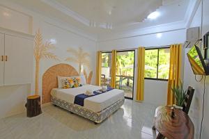 a bedroom with a bed and a tv in it at Villa Consolacion Resort in General Luna