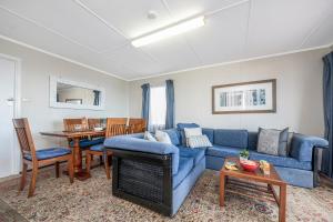 a living room with a blue couch and a table at Blue View - UNINTERRUPTED OCEAN VIEWS FOR MILES in Guilderton