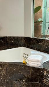 a bathroom with a bath tub with a towel on it at Pousada Shangrila RP in Ribeirão Preto