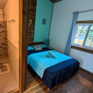 a bedroom with a bed in a room with a window at Casa Pelicano in Bocas del Toro