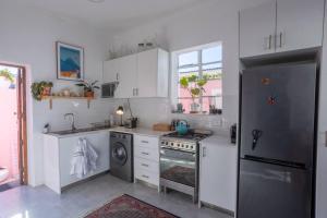 a kitchen with a stainless steel refrigerator and a dishwasher at The Dolls House in Cape Town +33 photos