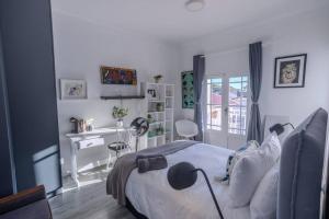 a bedroom with a bed and a desk in it at The Dolls House in Cape Town