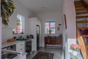 a kitchen with a sink and a stove top oven at The Dolls House in Cape Town