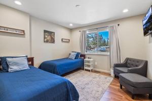 a bedroom with two beds and a chair and a window at Adventure Awaits - Pets - Hot tub - Fire pit in Mevers