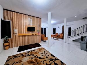 een grote woonkamer met een televisie en een bank bij Villa Putih in Cisarua