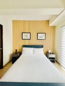 une chambre avec un grand lit blanc avec deux tables dans l'établissement 16 Cozy and Spacious Studio, à Cari Mayor