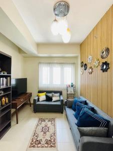 un salon avec un canapé bleu et une télévision dans l'établissement 16 Cozy and Spacious Studio, à Cari Mayor