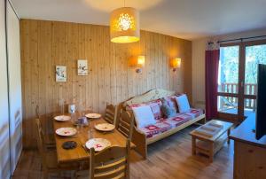 a dining room with a table and a couch at Cosy Montagne in Valmeinier