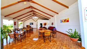 Un comedor con mesas y sillas de madera. en Edelmon't Beach, en Los Órganos