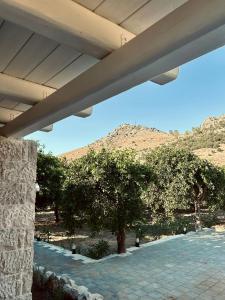 a view from under a building with trees and a mountain at Nerita's country houses in Néa Tírins