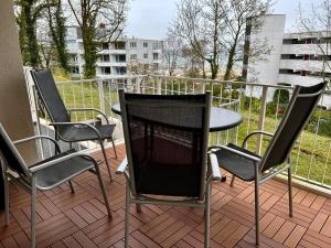 eine Terrasse mit 3 Stühlen und einem Tisch auf dem Balkon in der Unterkunft Residenz am Yachthafen, Whg 4 in Grömitz