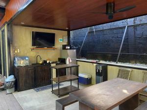 Zimmer mit einem Tisch und einem großen TV in der Unterkunft Mizukaze Tagaytay Japanese villa in Iruhin