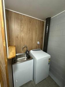 a small bathroom with a sink and a small refrigerator at TuiGlen in Dinsdale +13 photos