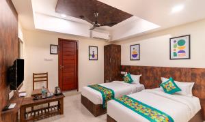 A bed or beds in a room at Treebo Rakshitha, Porur